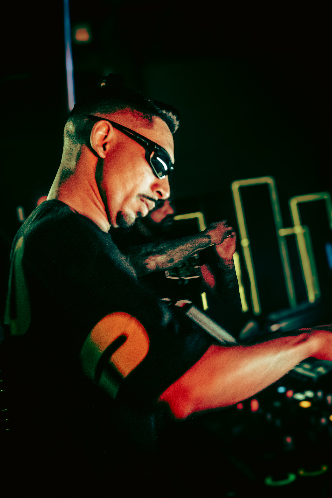 DJ Lucas Lira atrás da DJ booth com iluminação premium